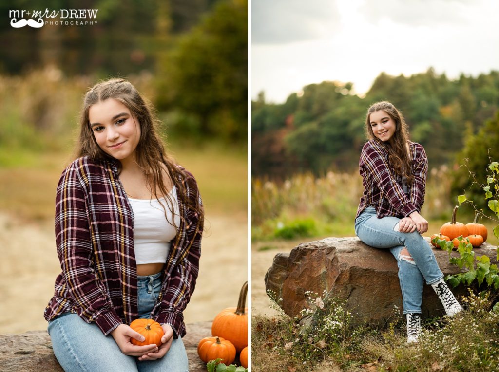 Chelmsford High Senior sitting with small pumpkins smiling at Heart Pond