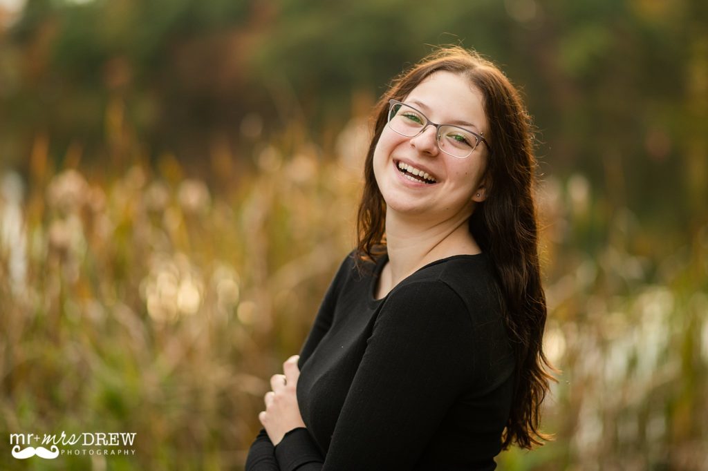 Senior laughing during fall photos at Heart Pond in Chelmsford MA